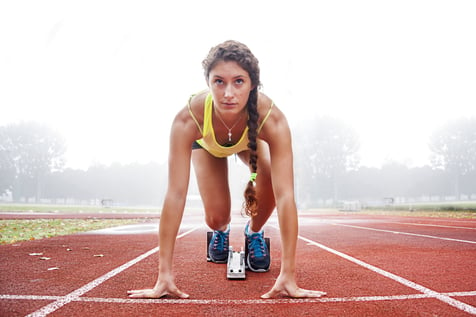 Girl at starting blocks racing