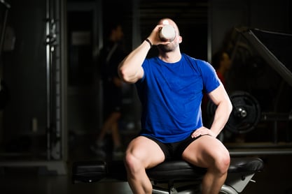 Guy sitting and drinking protein shake